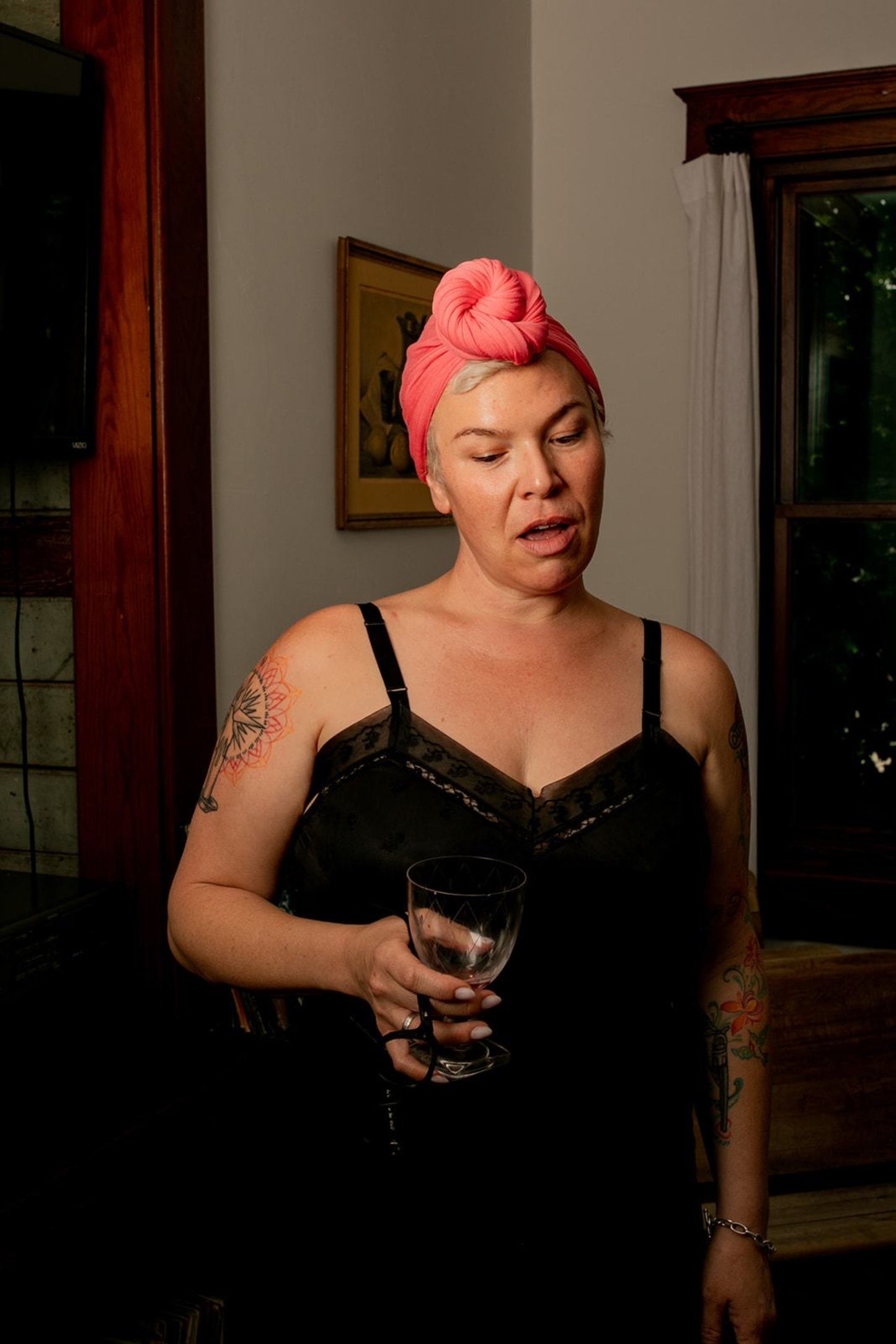 woman holds wine glass while using her luxury bamboo hair towel by Capillum to quickly dry her hair