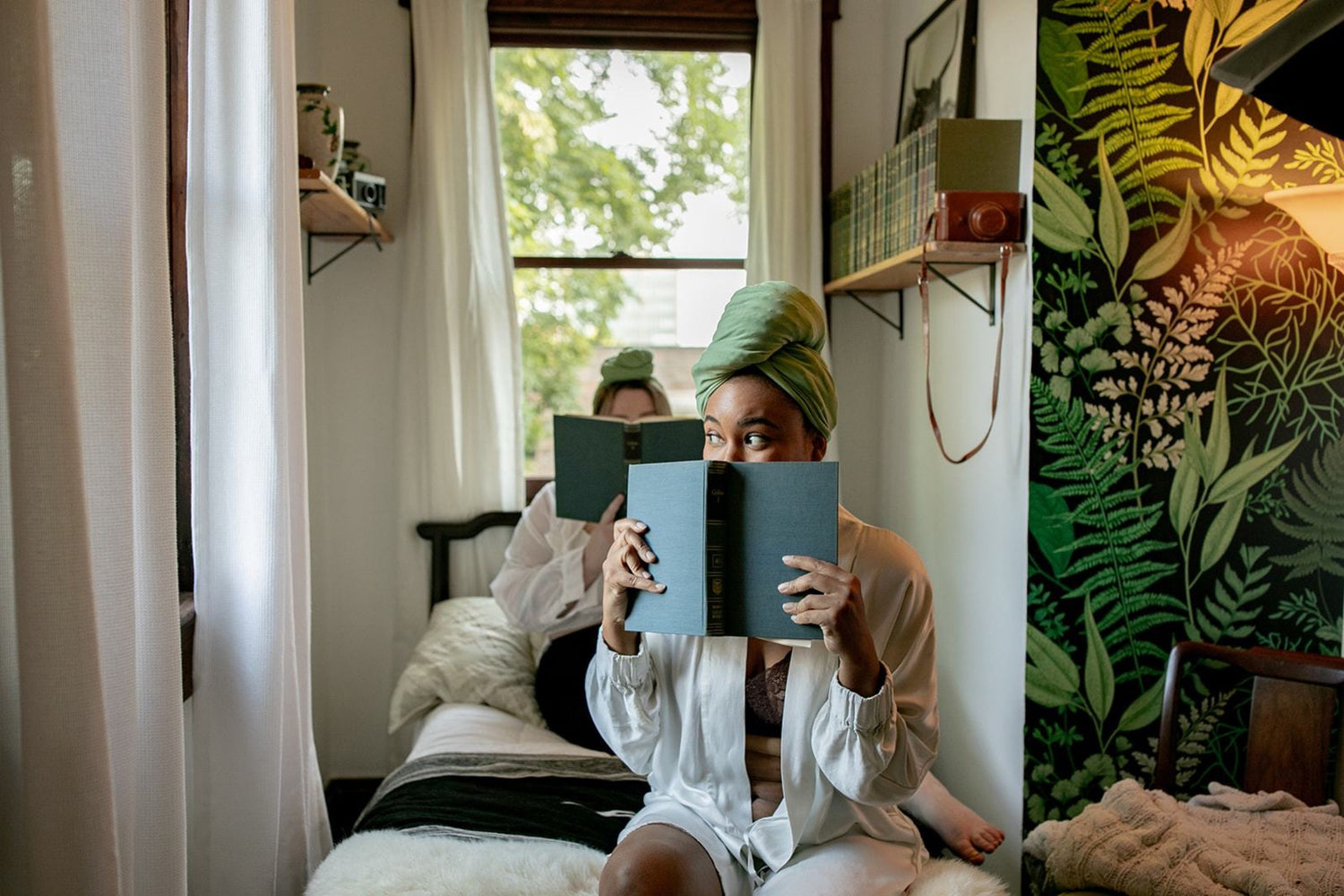 woman peaks over book while wearing Capillum Bamboo Hair Towel in green 